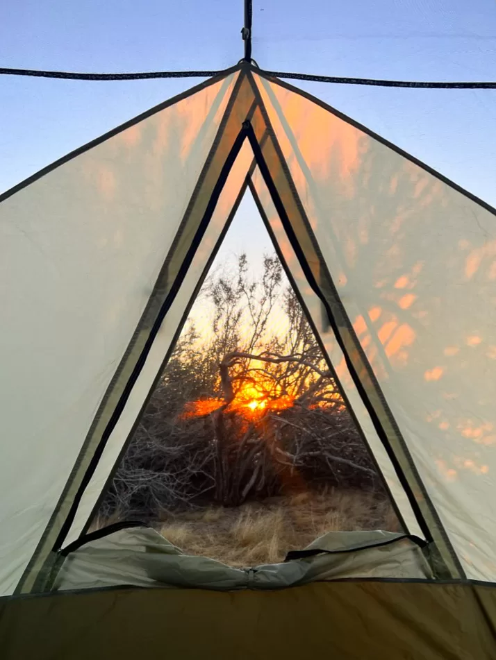 The sun poking over the horizon and lighting up the inside of a tent at Anza-Borrego Desert State Park.