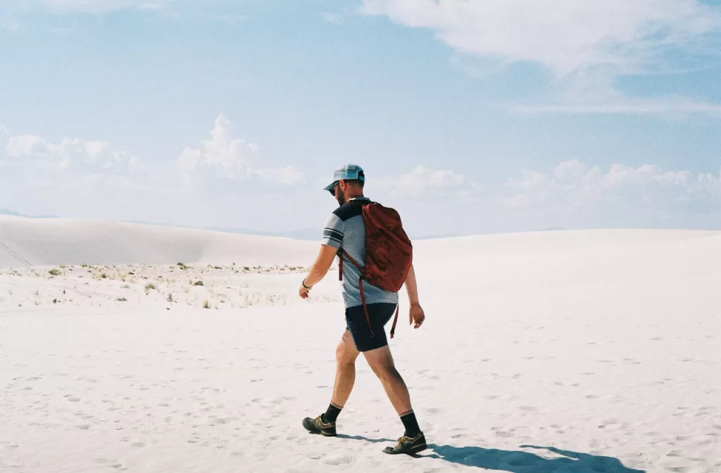 A hiker walking among the sand dunes at White Sands National Park.