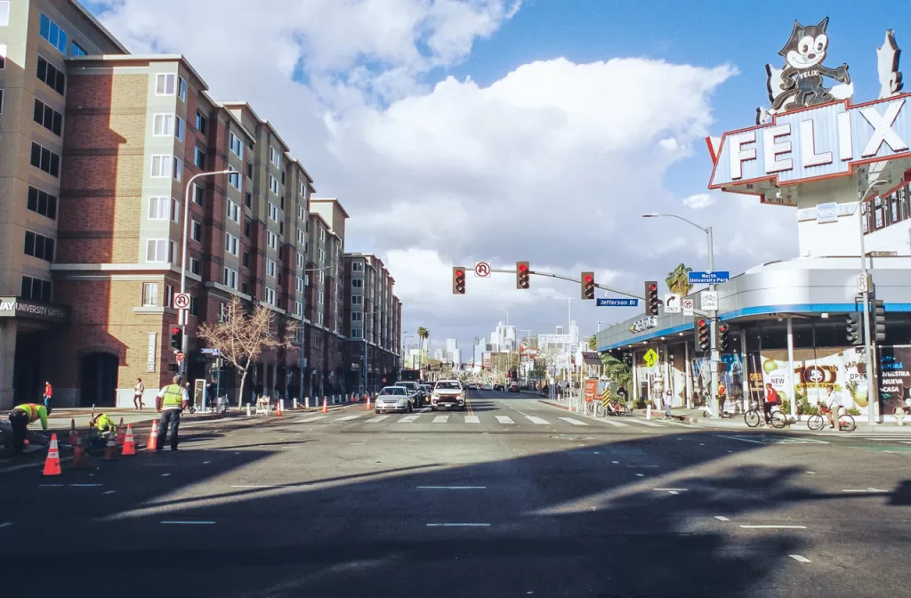 Figueroa Blvd by the University of Southern California and Felix Chevrolet, with downtown LA and large clouds in the distance.