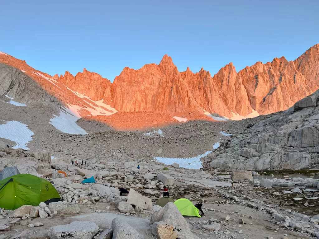 Tents pitched a Trail Camp below Mt. Whitney as the sun sets and casts an Alpenglow on the mountains. 