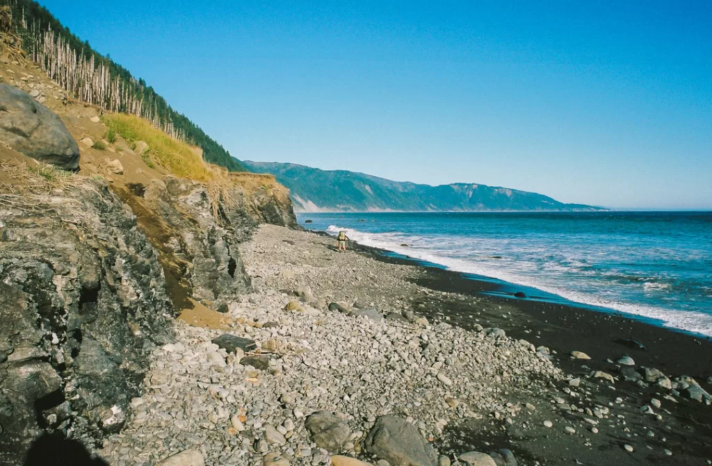 A hiker venturing into an impassible zone on the Lost Coast Trail. 