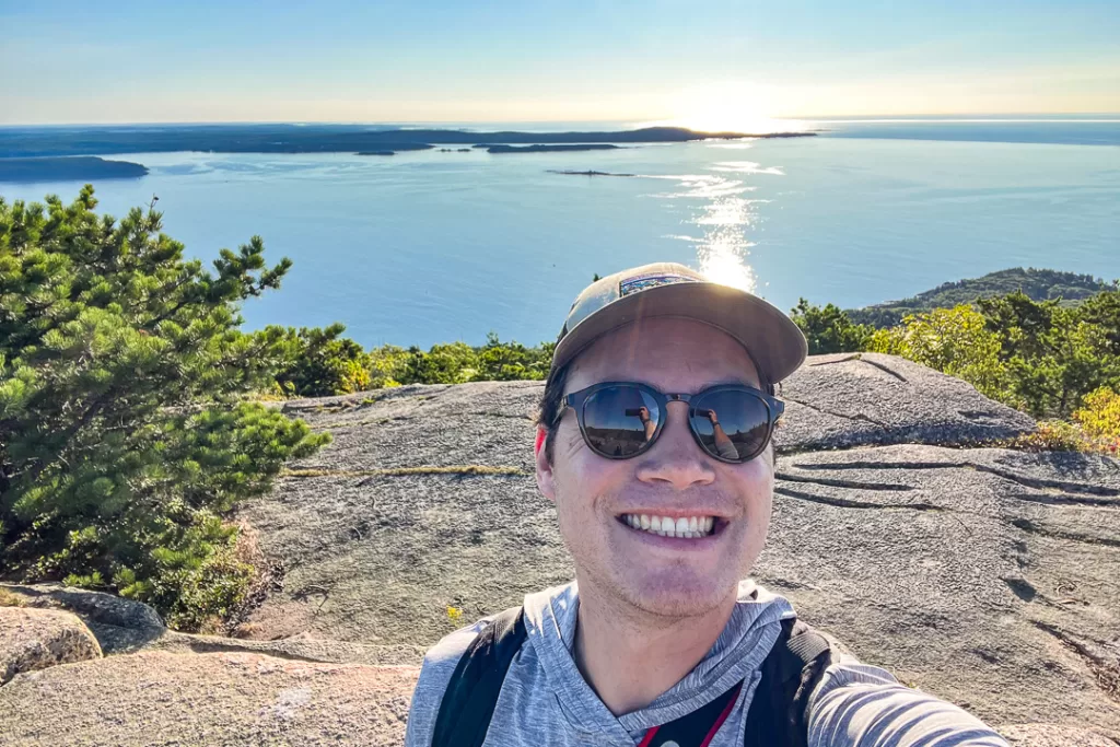 A hiker taking a selfie on top of Champlain Mountain.