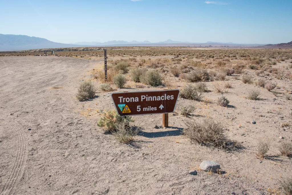 A sign that reads "Trona Pinnacles 5 miles" and an arrow pointing to the pinnacles. 