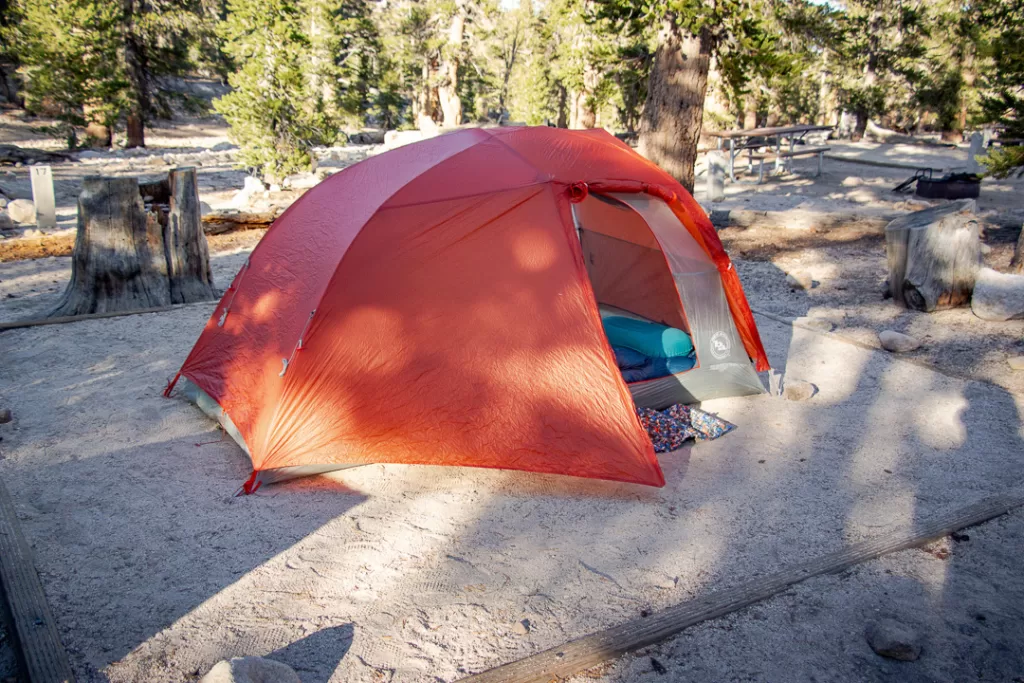 A tent with a pillow and sleeping bag inside. 