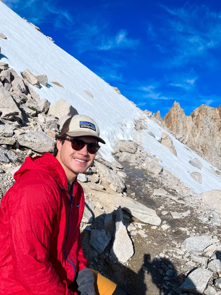 A hiker taking a rest hiking up Mount Whitney. 