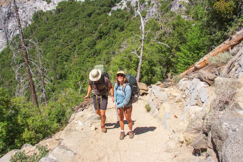 Two backpackers, who were able to adventure outdoors on a budget by getting their gear used, hiking up the Yosemite Falls trail. 