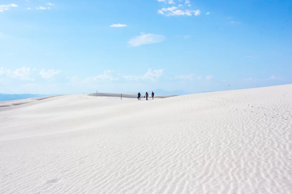 Hikers hiking along the dunes in White Sands National Park.