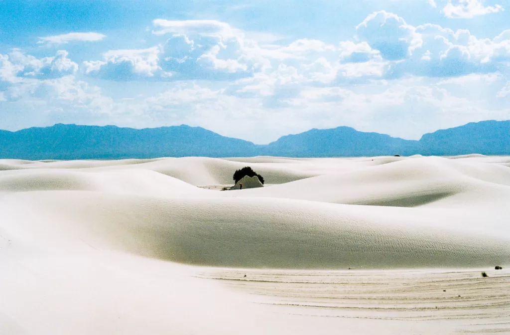 A hiker walking among the sand dunes. 