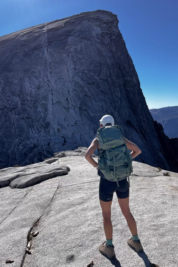 A hiker staring at the cables during their hike to the top of Half Dome. 