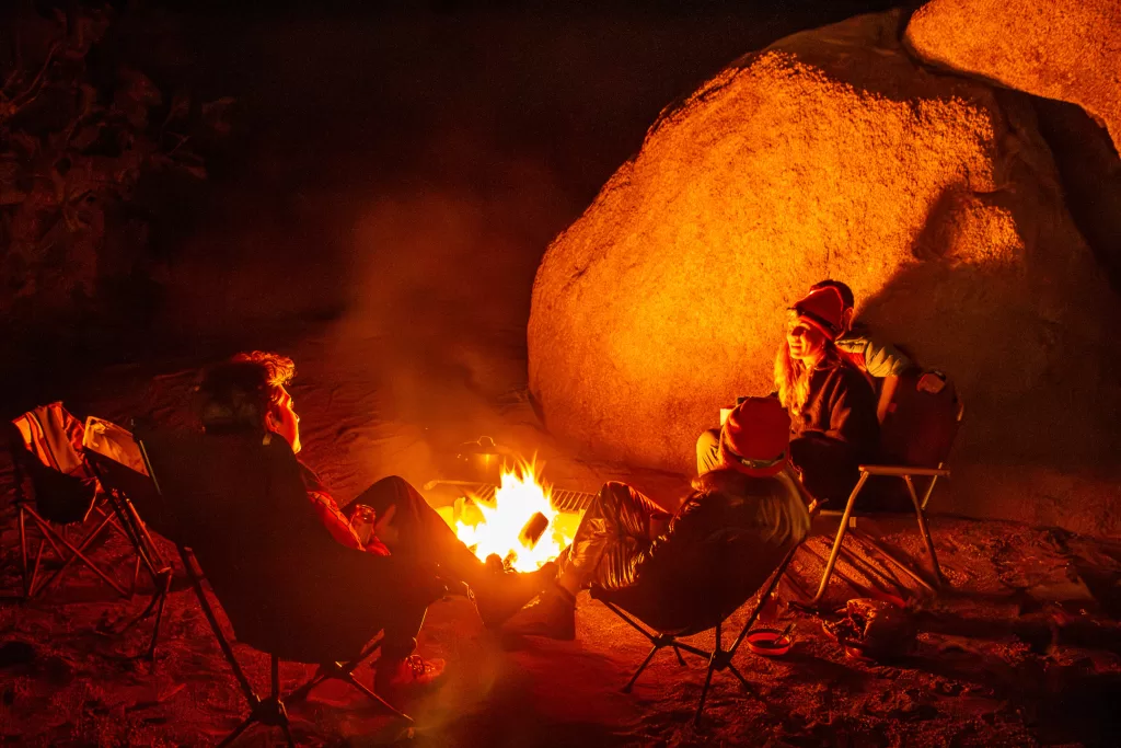 people sitting around a campfire as a way to spend more time outside.